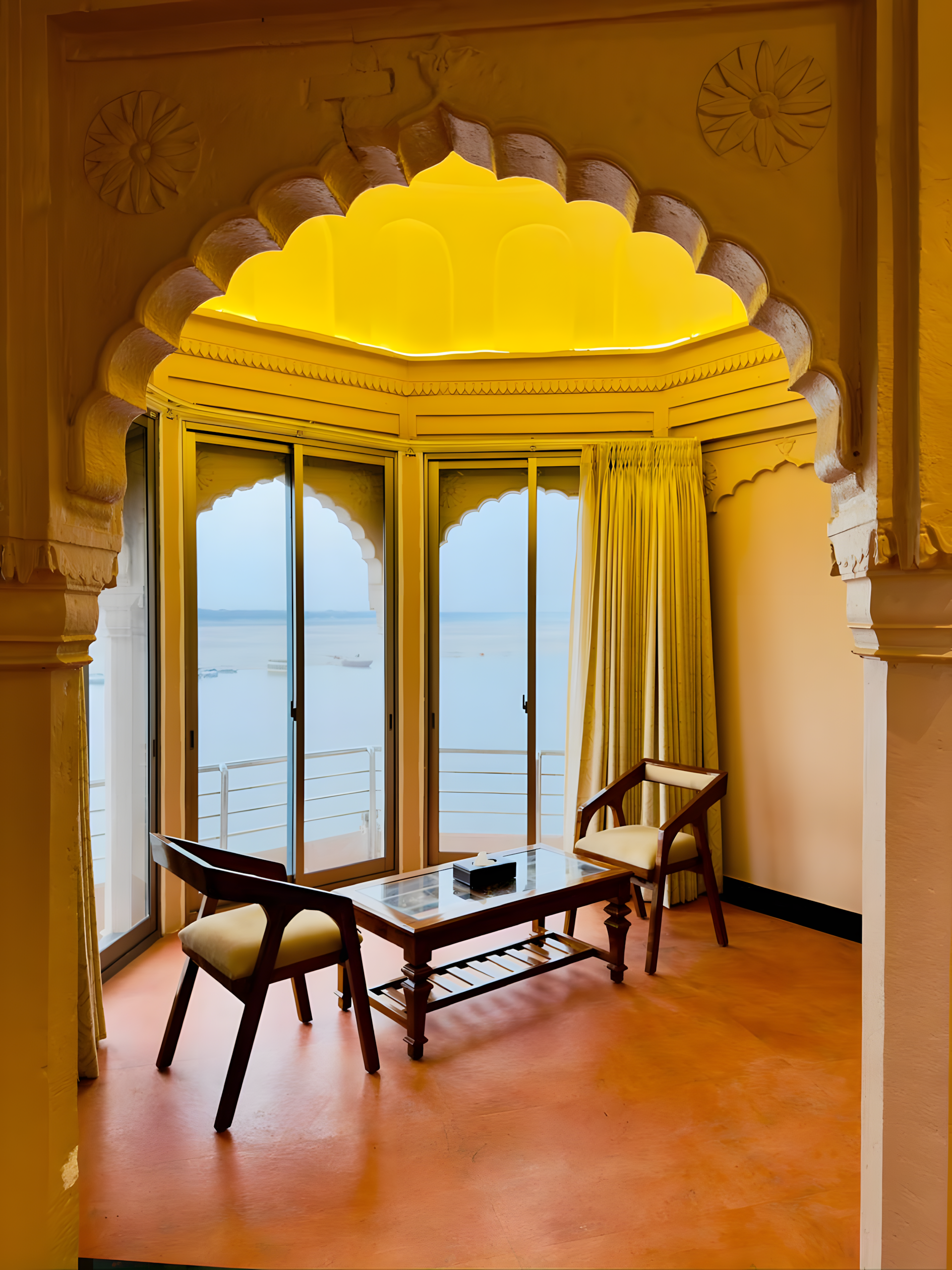 Peacock arch chhajja sitting area at Maharana Mahal heritage hotel Varanasi — ornate carved peacock motif arch framing Ganga river view, teak chairs — unique Rajput palace feature, boutique hotel Kashi