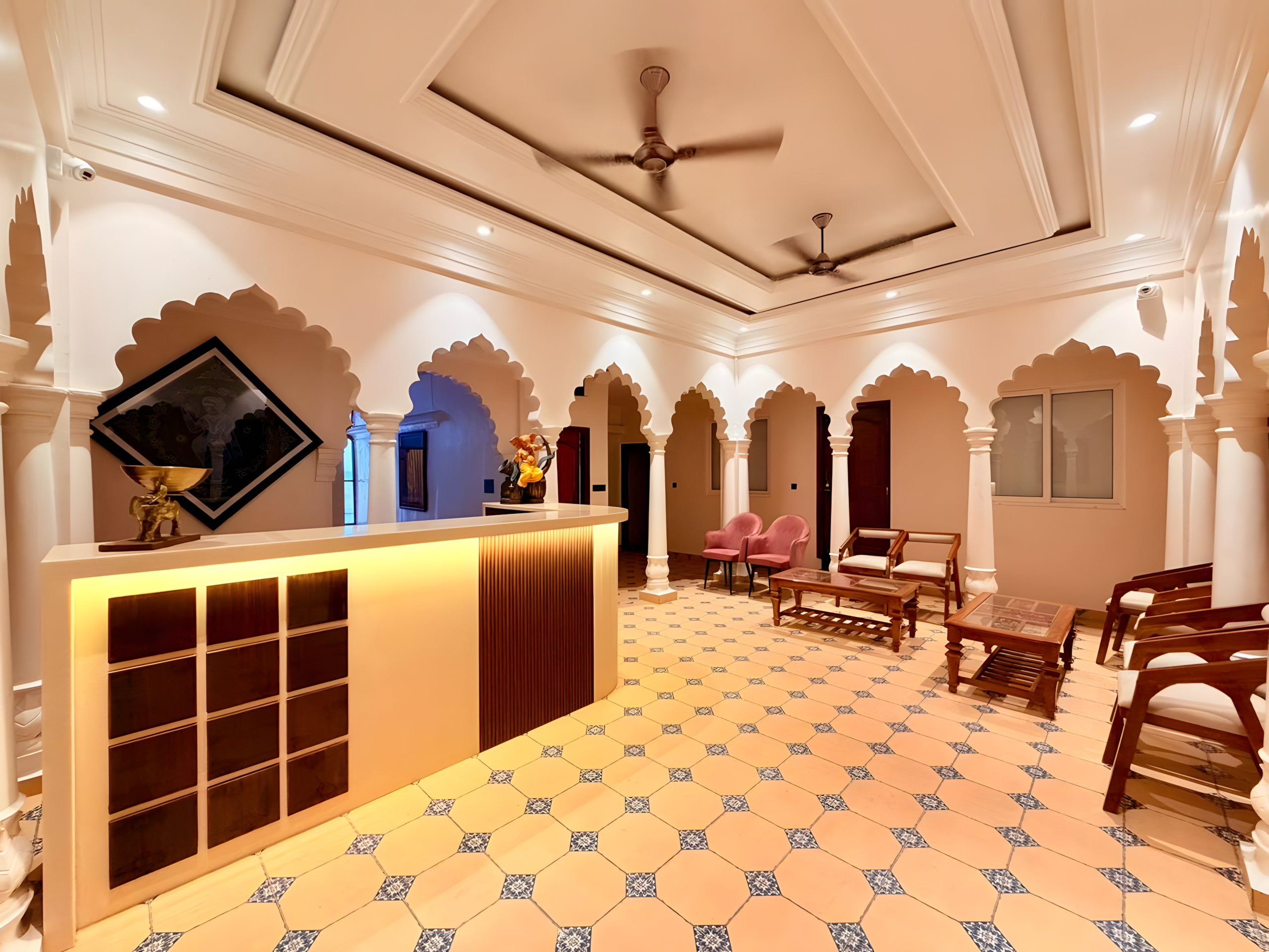 Luxury bathroom at Maharana Mahal heritage hotel Varanasi — white soaking bathtub beside a natural ancient tree trunk growing through the room, Rajasthani mosaic tile floor — boutique palace hotel India